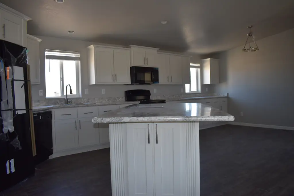 Kitchen finish with dark LVP flooring inside a display model on the Redrock Homes lot